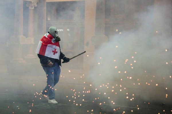 Photo: A person carrying a flag on the back takes part in a protest against the government's decision to suspend talks on joining the European Union, in Tbilisi, Georgia December 3, 2024. Credit: REUTERS/Irakli Gedenidze