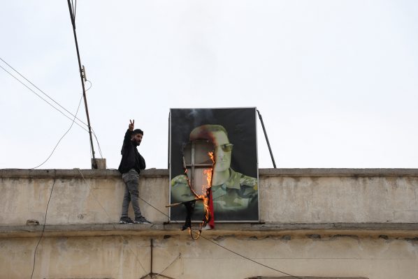 Photo: A person gestures next to a burning picture of President Bashar al-Assad, after rebels seized the capital and ousted the president, in Qamishli, Syria December 8, 2024. Credit: REUTERS/Orhan Qereman