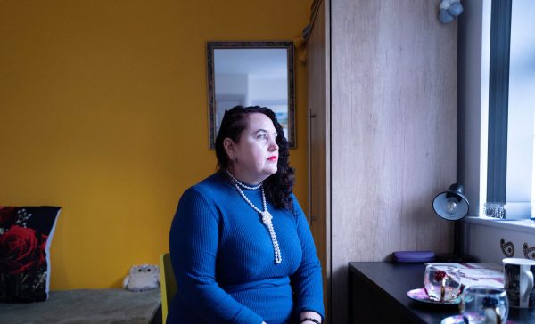 Photo: Ukrainian refugee Liudmyla (Mila) Panchenko looks out of a window while sitting on a chair at her current residence in Hatfield, Britain, February 21, 2024. Credit: REUTERS/Anna Gordon