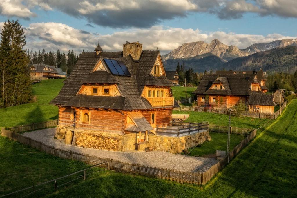 una grande casa di tronchi con montagne sullo sfondo di Willa Giewontka a Witów