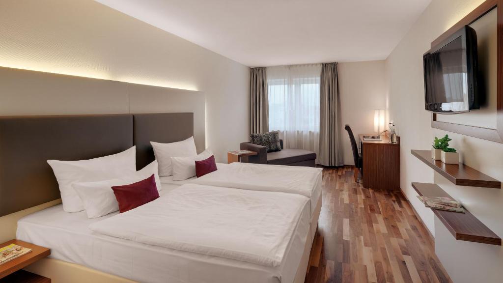 Giường trong phòng chung tại Hotel Newton Heilbronn