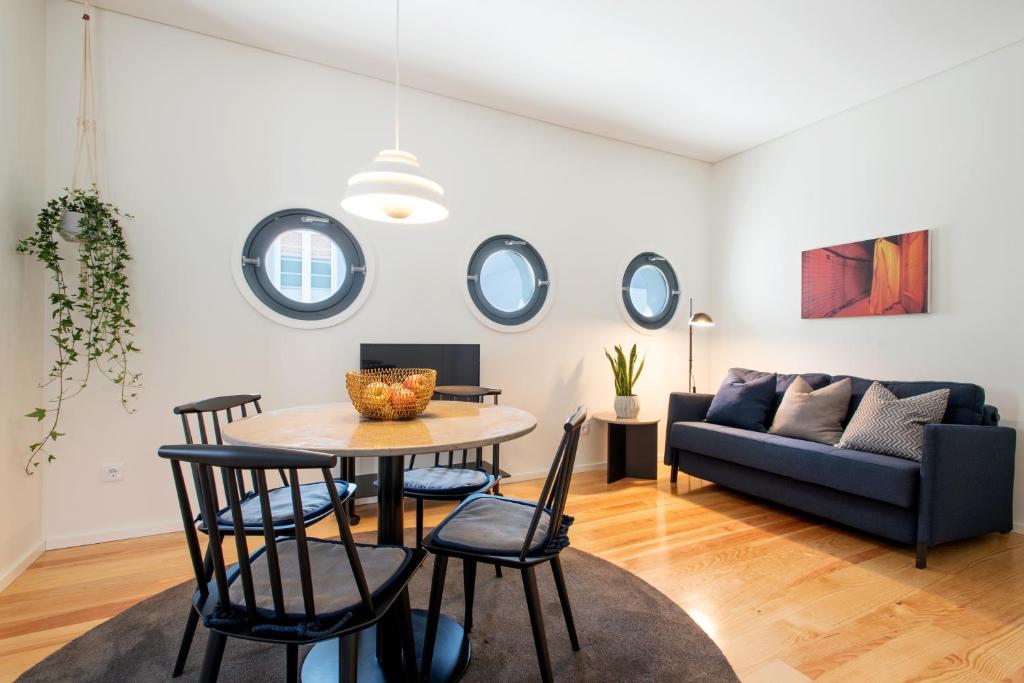 uma sala de estar com uma mesa e cadeiras e um sofá em Oporto Serviced Apartments - Alvares Cabral no Porto