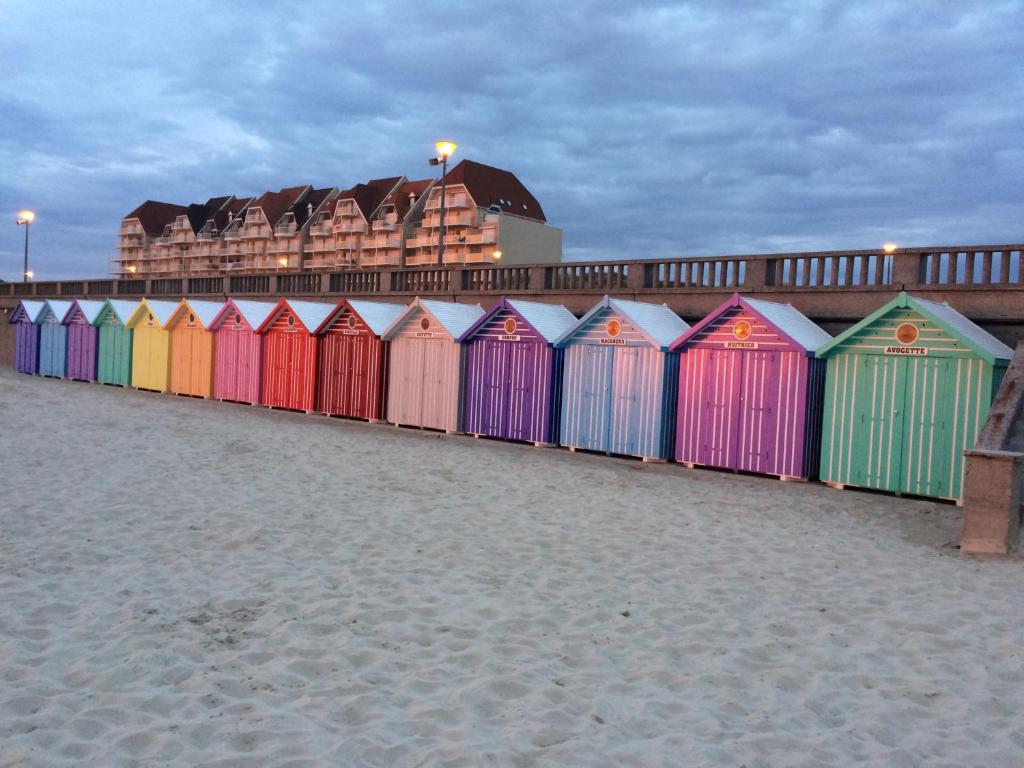 una fila di capanne colorate sulla spiaggia di STELLA APPART 2 chambres à 100 ml de la plage wifi fibre a Stella-Plage