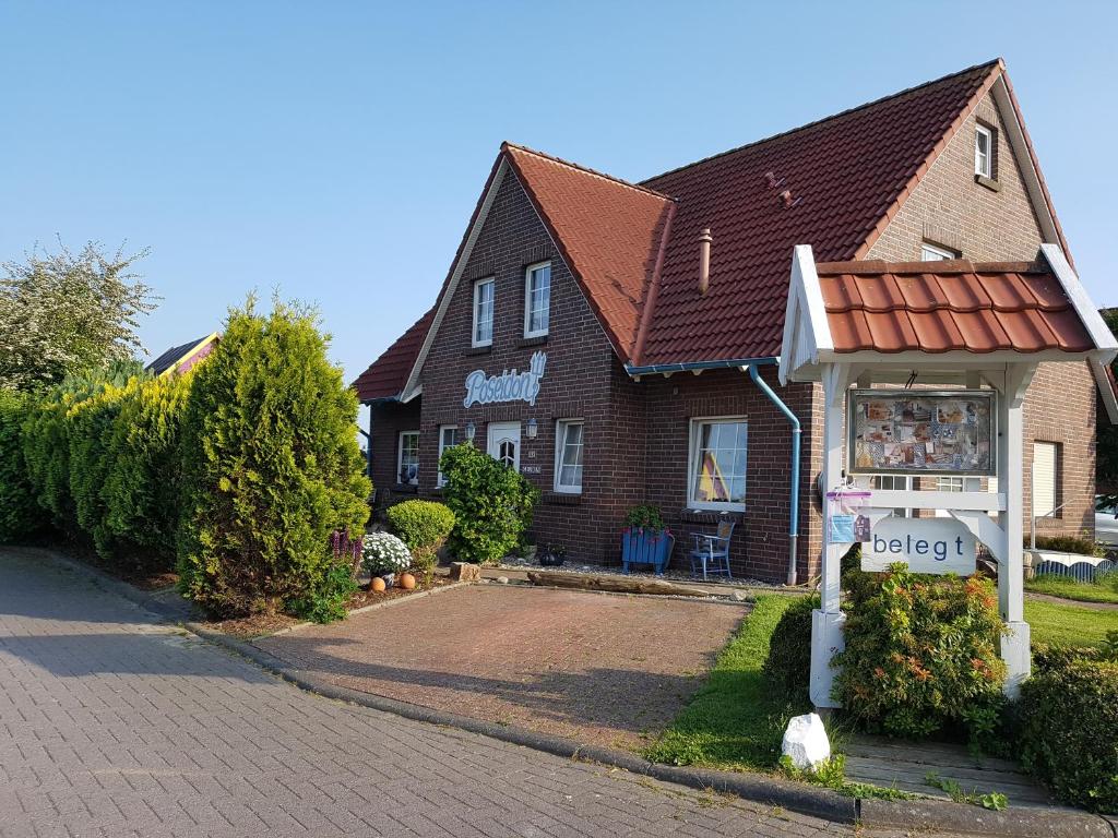 una casa con un cartel delante de ella en Ferienhaus Poseidon, en Neuharlingersiel