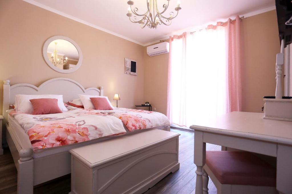 a bedroom with a bed and a table and a window at Shabby chic rooms in Zadar