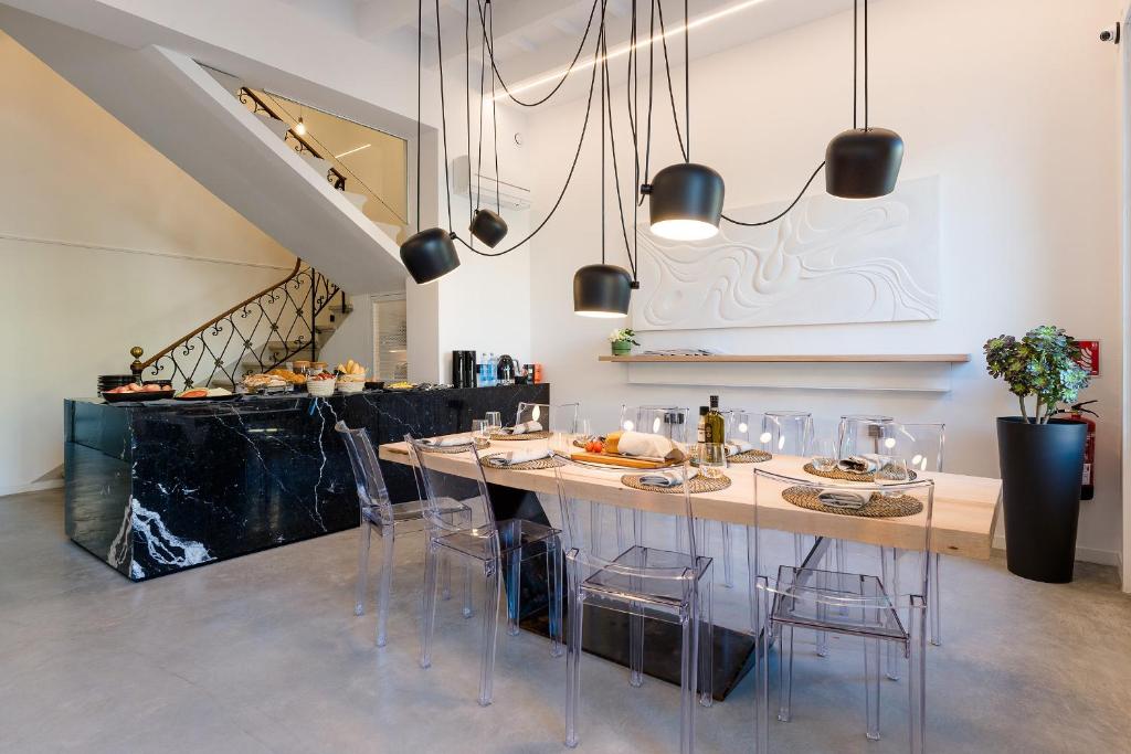 a dining room with a table and stools at Sodium Boutique Hotel in Ciutadella