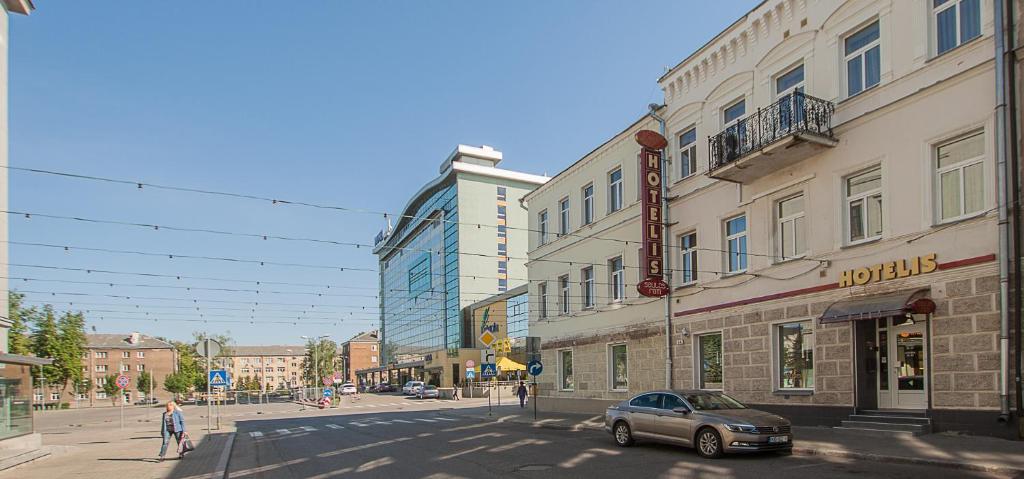 een auto staat geparkeerd in een stadsstraat met gebouwen bij Saules rati in Daugavpils