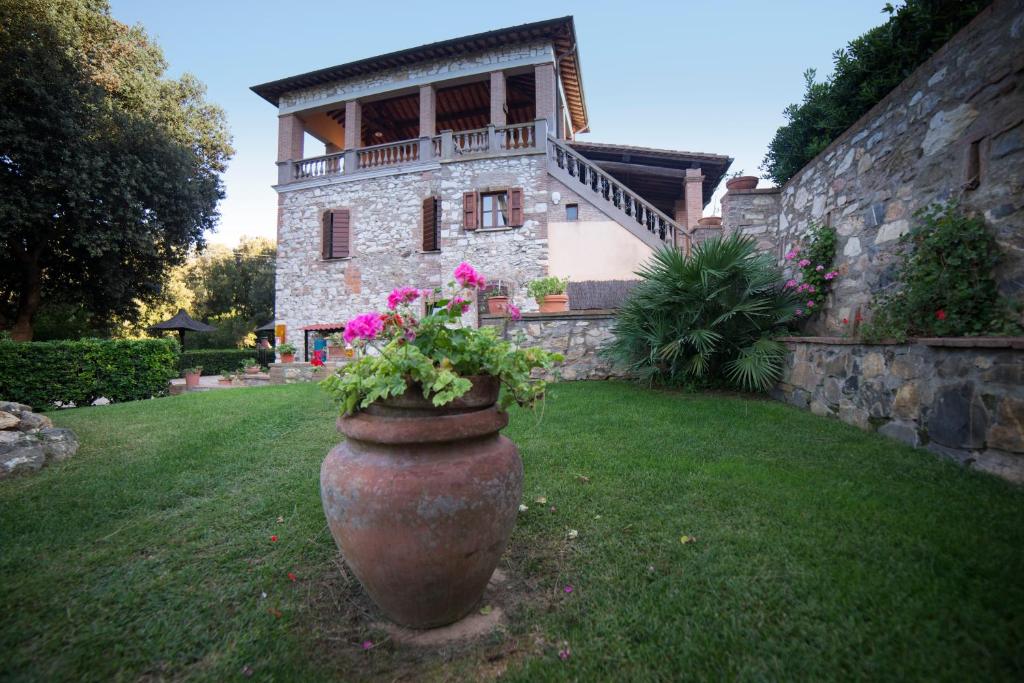 um grande vaso com flores em frente a uma casa em Il Castagno Toscana em Campiglia Marittima