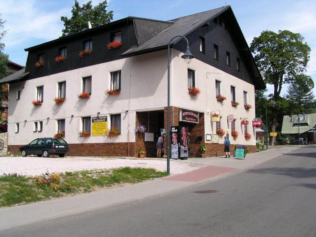 un grande edificio bianco con tetto nero di Hotel Anna a Harrachov