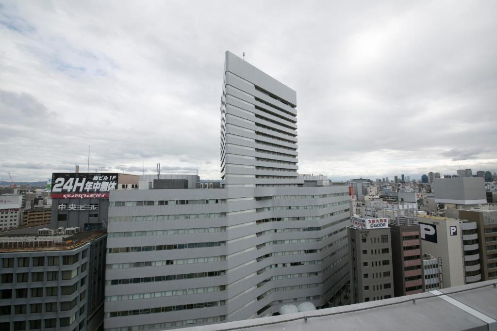 een hoog wit gebouw bovenop een stad bij Shin Osaka Washington Hotel Plaza in Osaka