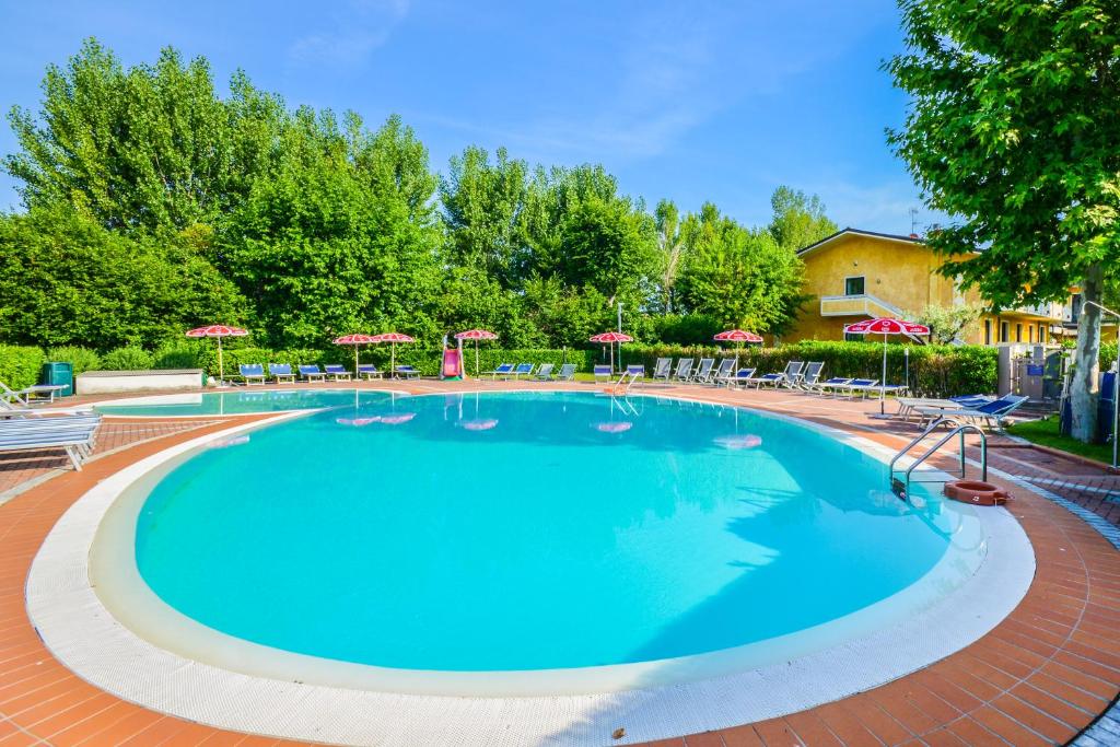 ein großer Pool mit Stühlen und Sonnenschirmen in der Unterkunft Hotel Riel in Sirmione