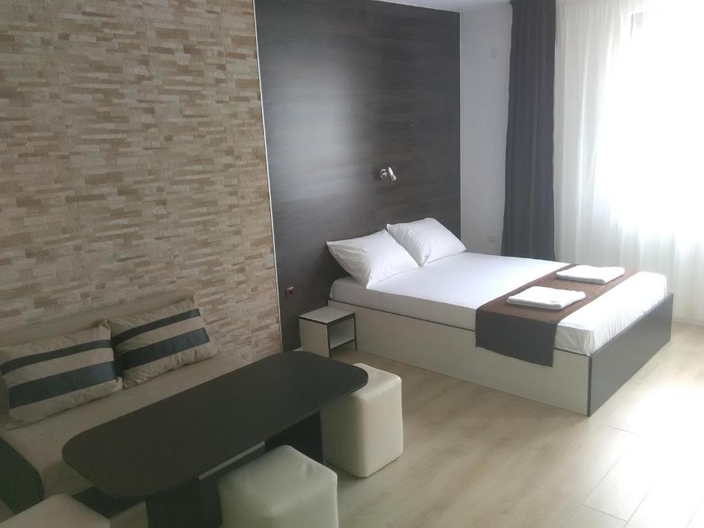 - une petite chambre avec un lit et une table dans l'établissement Apartments Hristovi, à Sandanski