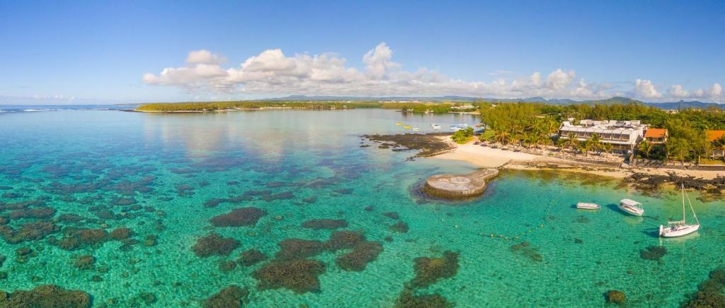 ブルー・ベイにあるLe Peninsula Bay Beach Resort & Spaの海上ボートが浮かぶビーチの空中ビュー