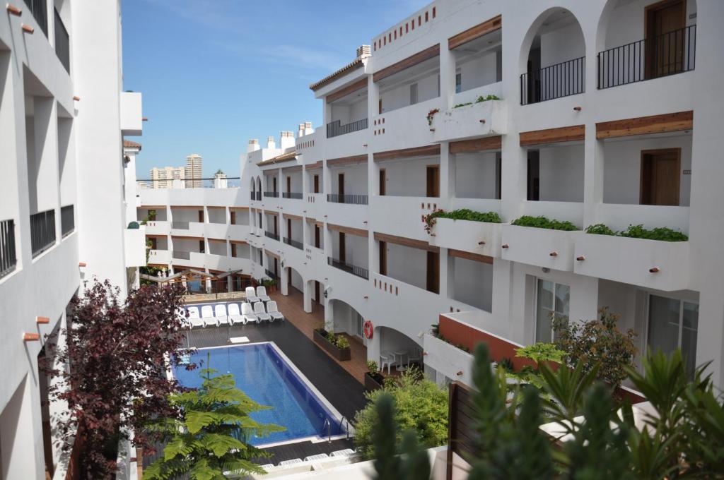 un immeuble d'appartements avec une piscine au milieu dans l'établissement Aparthotel Puerto Mar, à Peñíscola