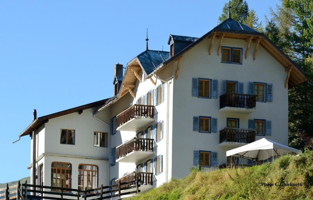 een wit gebouw met balkons op een heuvel bij Hotel de la Sage in La Sage