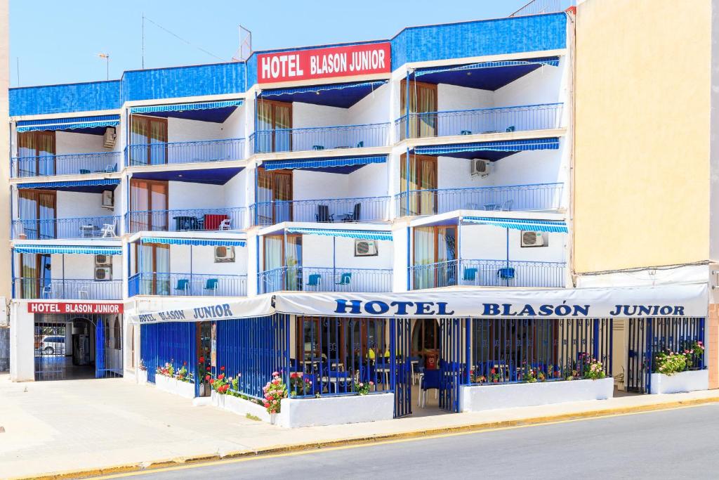 un hôtel avec des balcons bleus dans une rue dans l'établissement Hotel Blason Junior, à Peñíscola