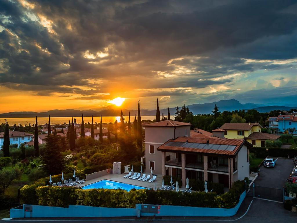 - un coucher de soleil sur une villa avec piscine dans l'établissement Hotel Relais Agli Olivi, à Lazise