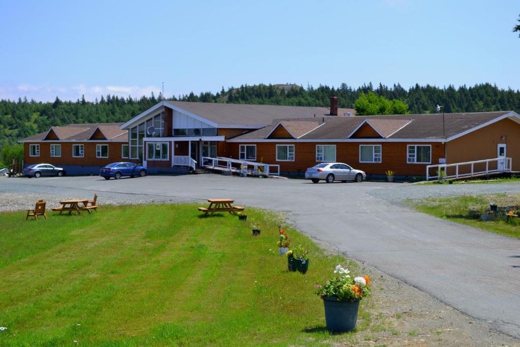 un edificio con parcheggio con panchine e fiori di Silverwood Inn Hotel Bay Roberts a Bay Roberts