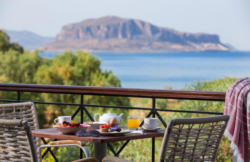 - une table avec de la nourriture et des boissons sur le balcon dans l'établissement Iris Beach Hotel, à Monemvasia