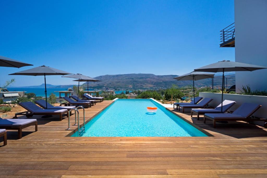 una piscina con sedie e ombrelloni in un edificio di Seametry Apartments a Souda (Suda)