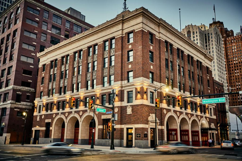 un gran edificio de ladrillo en una calle de la ciudad con coches en Detroit Foundation Hotel, en Detroit