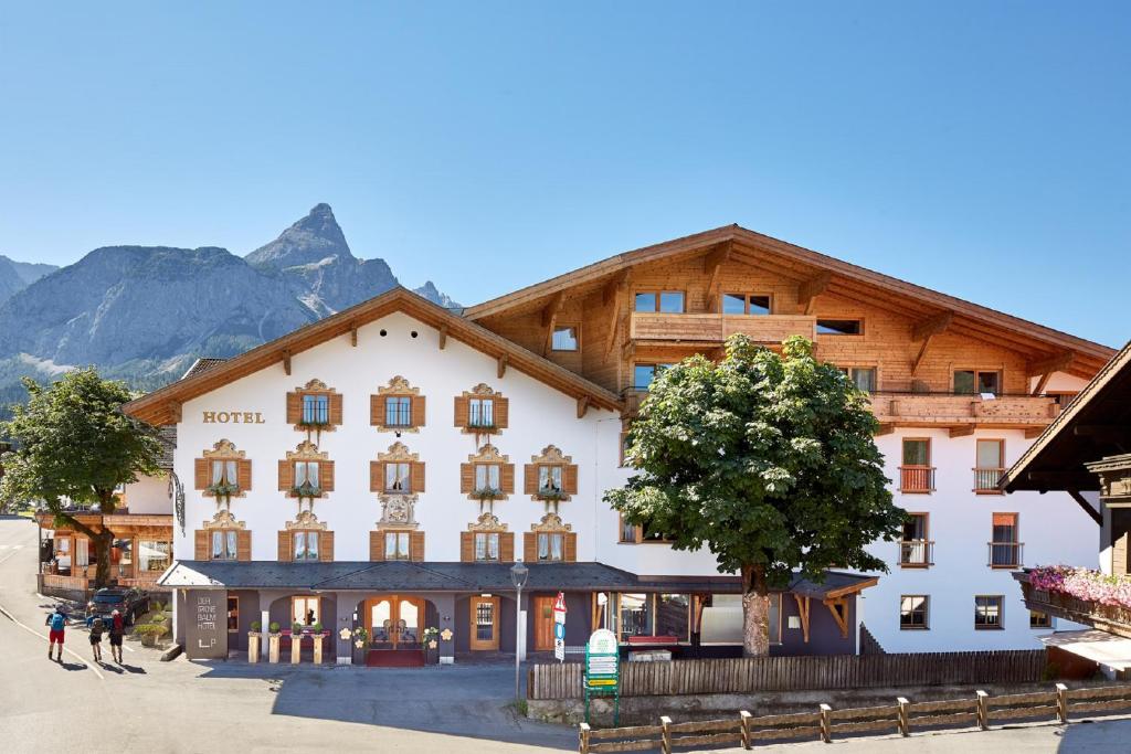 um grande edifício em frente a uma montanha em der grüne Baum Mountain Boutique Hotel em Ehrwald