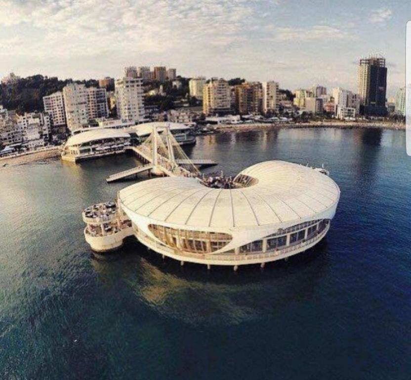 een grote boot in het water naast een stad bij Ventus Harbor Hotel in Durrës