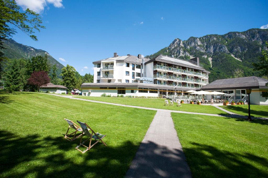 un grande edificio su un prato con due sedie di Parkhotel Hirschwang a Reichenau