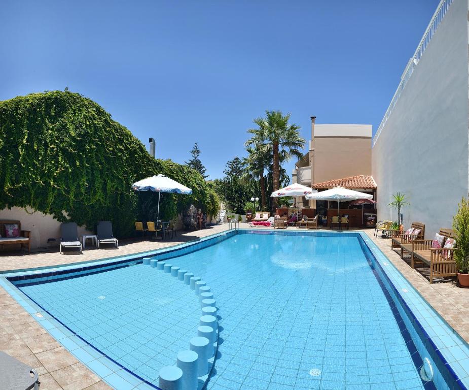 une grande piscine avec des chaises et des parasols dans l'établissement Akatos Hotel, à Agia Marina