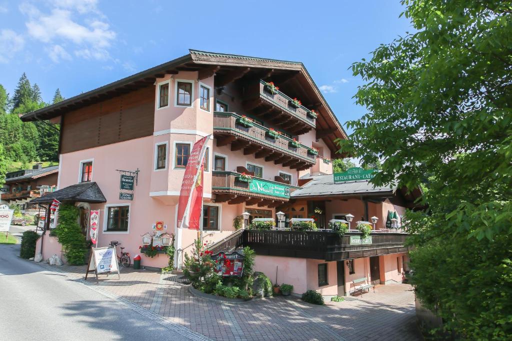 ein großes Gebäude mit Balkon auf einer Straße in der Unterkunft Landgasthof Neuwirt in Lofer