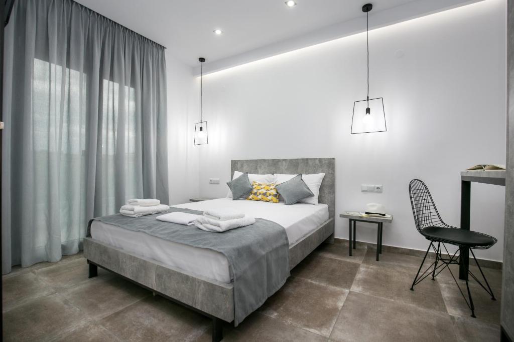 1 dormitorio con cama, escritorio y silla en Il Grigio Apartments, en Limenaria