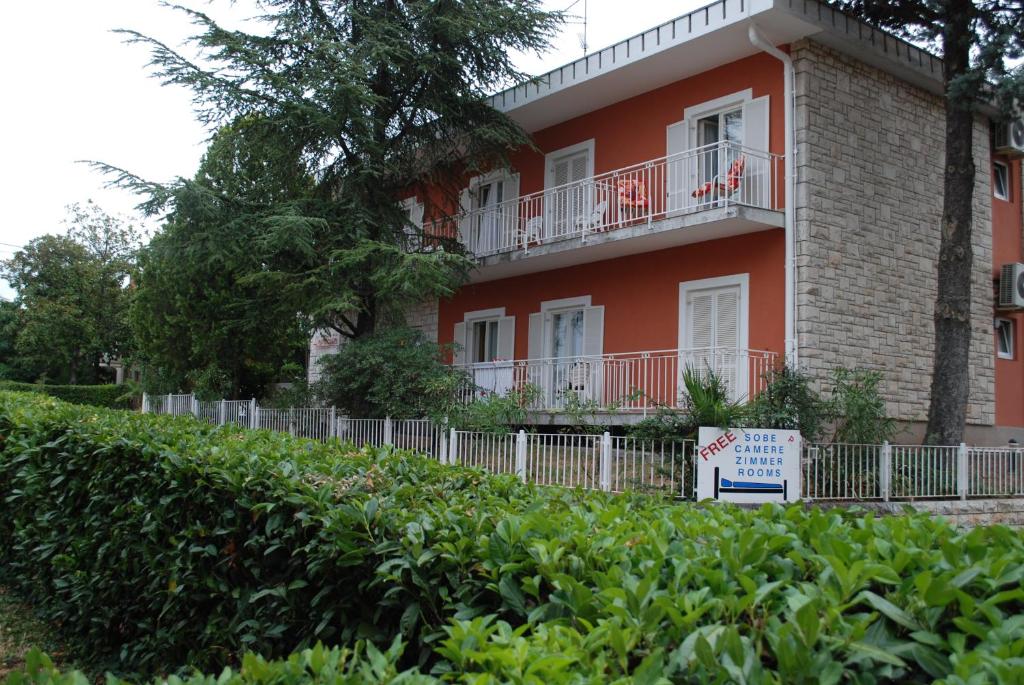 um edifício vermelho com um sinal em frente em Bed and Breakfast La Rossa em Umago