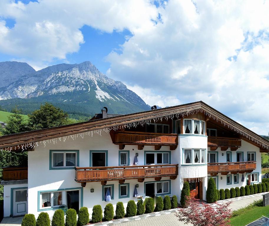 ein großes Gebäude mit einem Berg im Hintergrund in der Unterkunft Apartments Scheffau in Scheffau am Wilden Kaiser