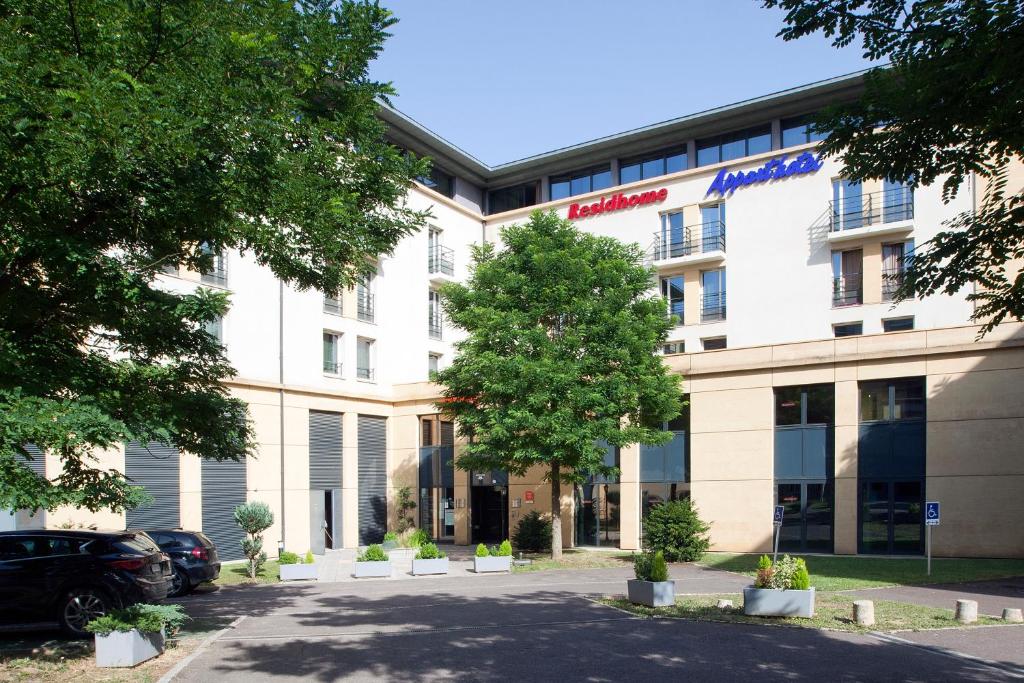 ein Bürogebäude mit einem Baum davor in der Unterkunft Residhome Metz Lorraine in Metz