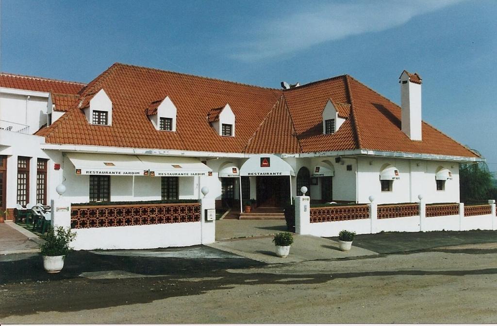 una grande casa bianca con tetto rosso di Hotel Jardim a Elvas