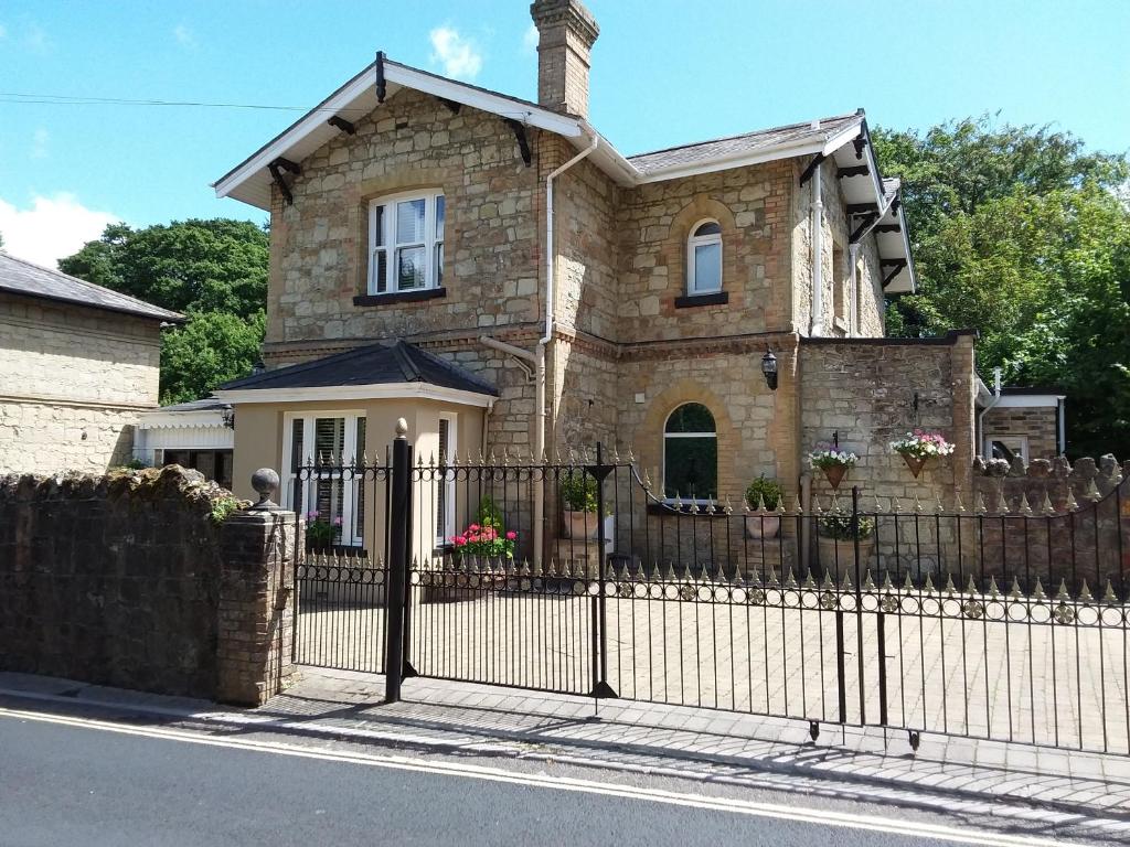 een stenen huis met een smeedijzeren hek bij Chine Side in Shanklin