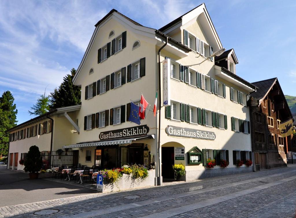 a large white building on the side of a street at Gasthaus Skiklub in Andermatt