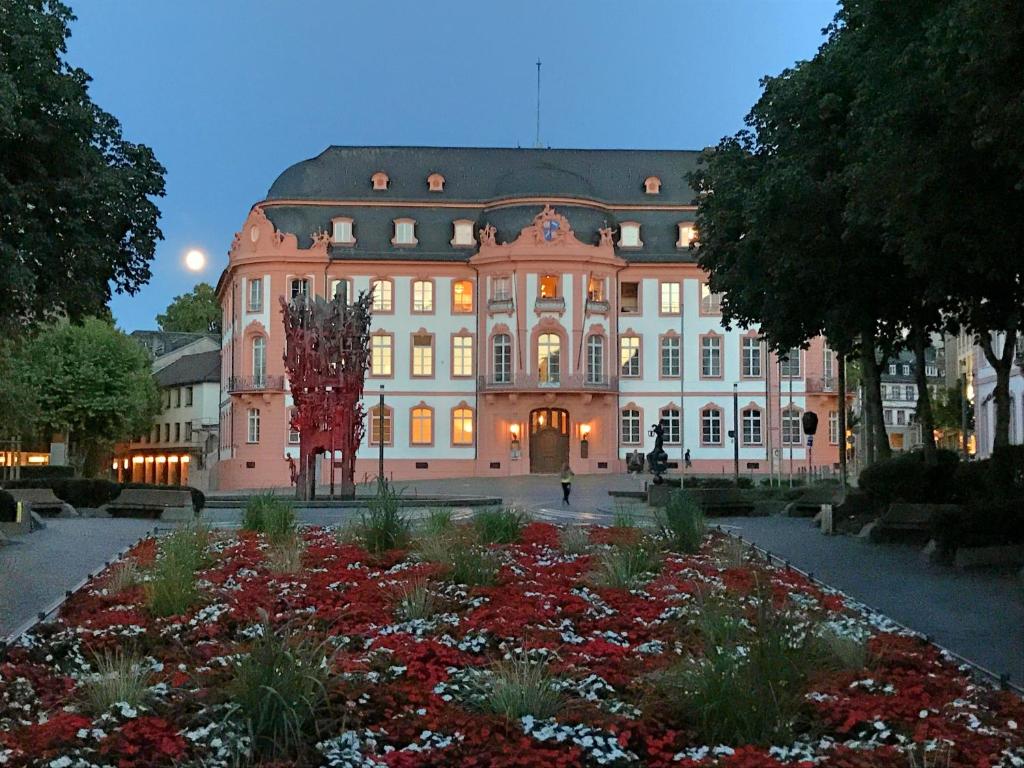 a large building with a garden in front of it at Osteiner Hof by The Apartment Suite in Mainz