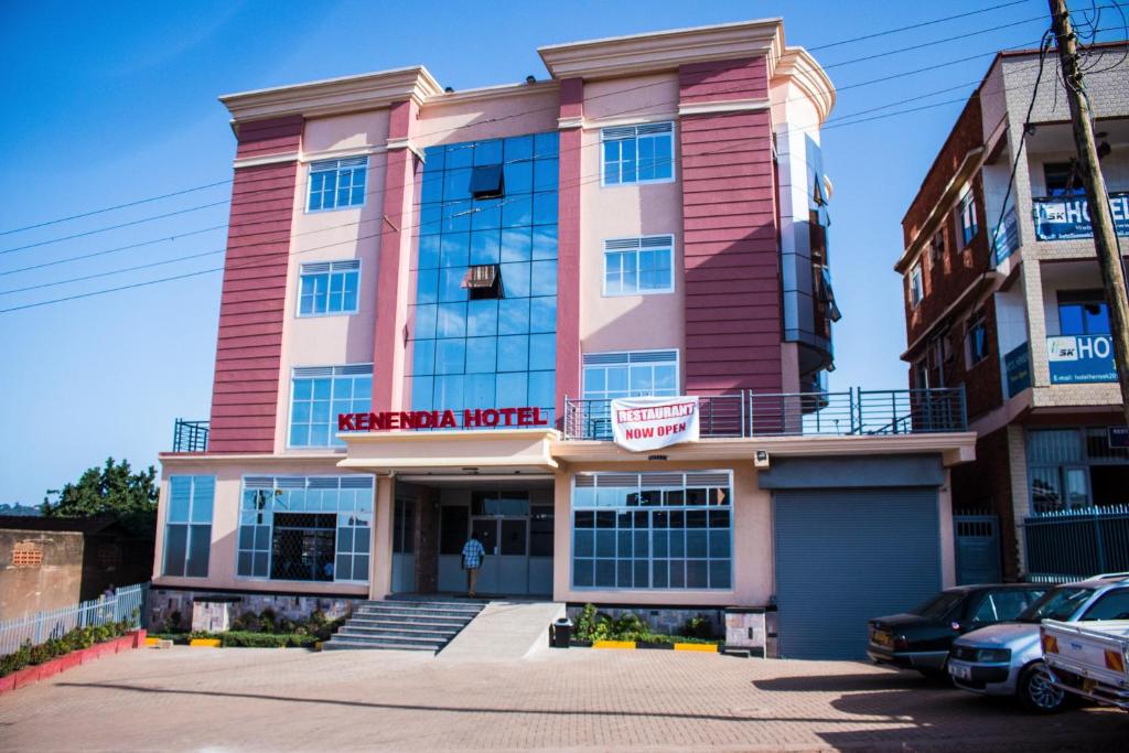 Um edifício cor-de-rosa com uma placa que diz "Motel Meridiano" em Kenendia Hotel em Kampala