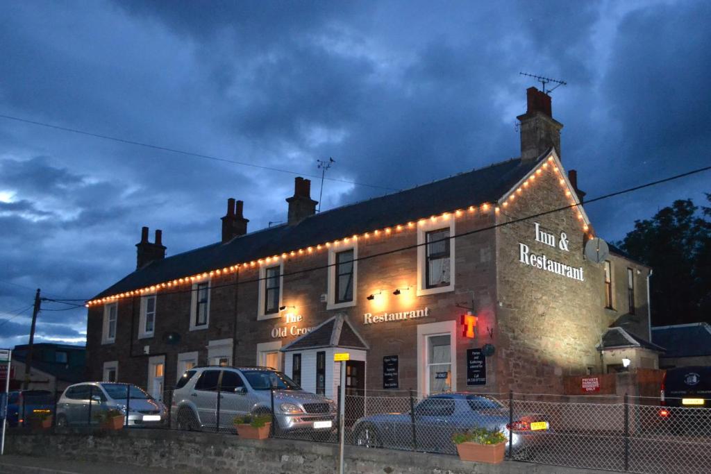 un bâtiment avec des lumières sur son côté dans l'établissement The Old Cross Inn, à Blairgowrie