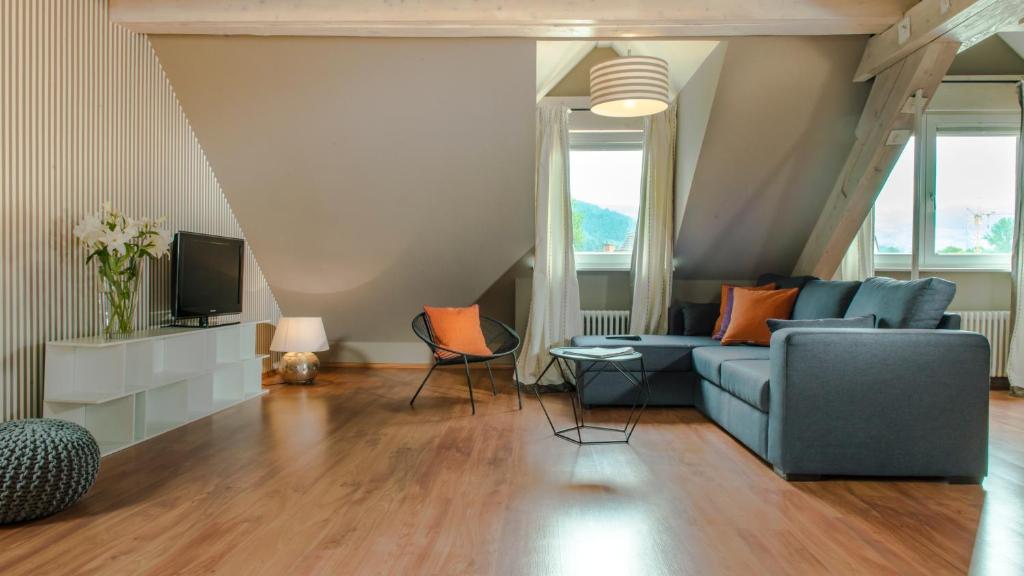 a living room with a blue couch and a tv at Hotel & Restaurant Sonne in Kirchzarten