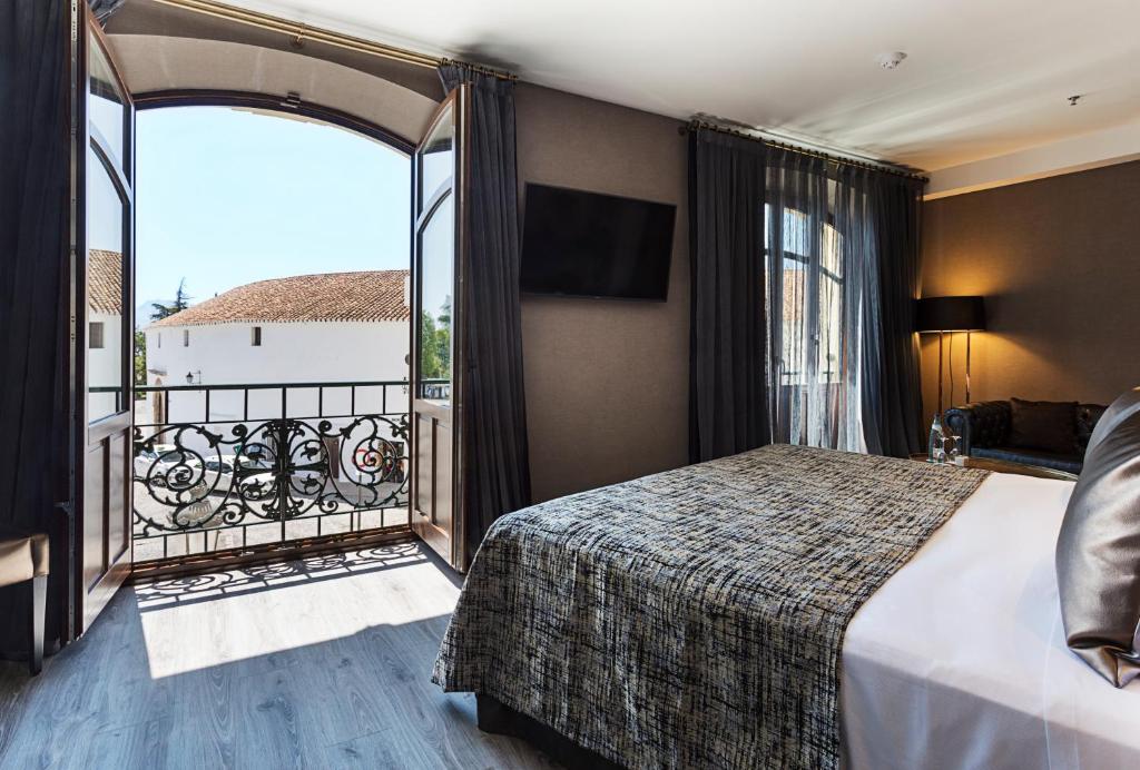 een hotelkamer met een bed en een balkon bij Catalonia Ronda in Ronda