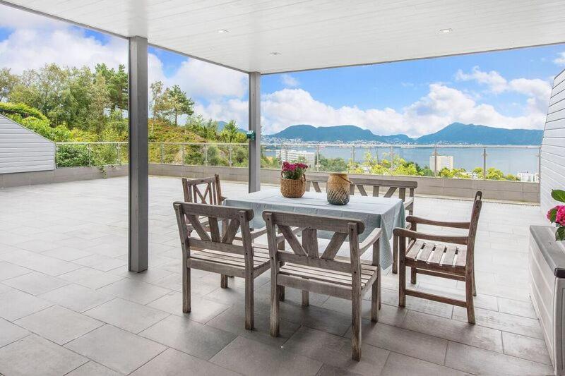 una mesa y sillas en un patio con vistas al agua en Øyjorden Apartment, en Bergen