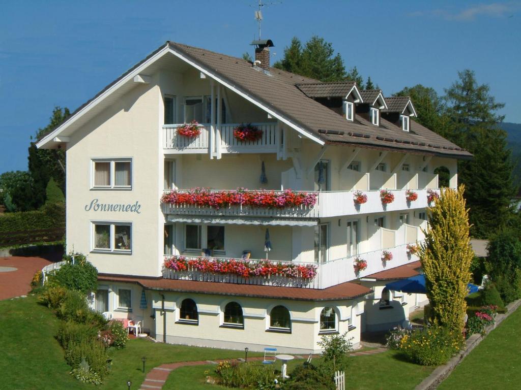 un gran edificio blanco con flores en los balcones en Pension Sonneneck, en Bayerisch Eisenstein