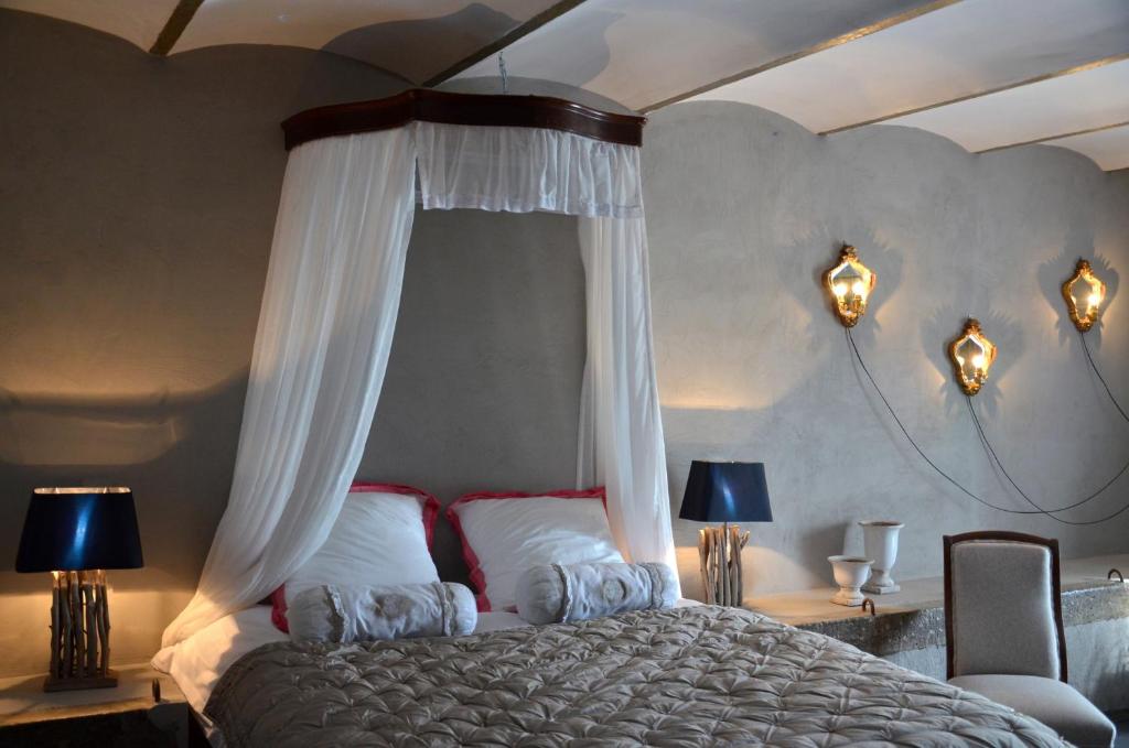 a bedroom with a large bed with a canopy at B&B La ferme du doux in Libramont