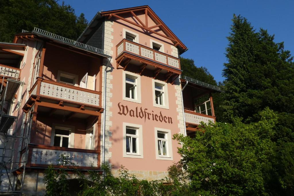 een roze gebouw met een bord erop bij Bio-Hotel Villa Waldfrieden in Bad Schandau