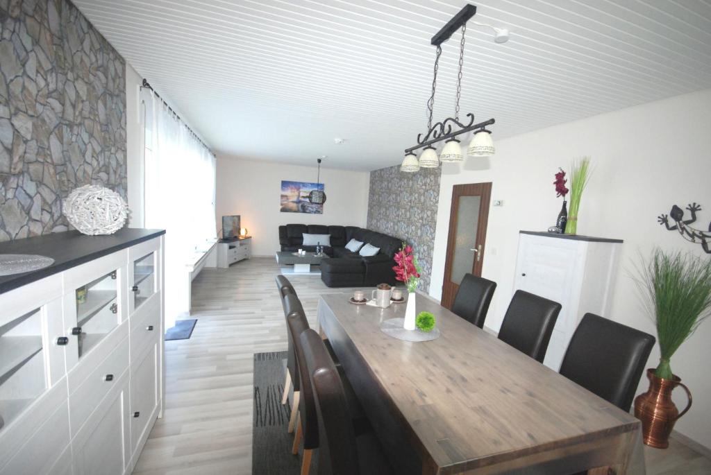 a kitchen and living room with a wooden table and chairs at Gästehaus Spengler in Celle