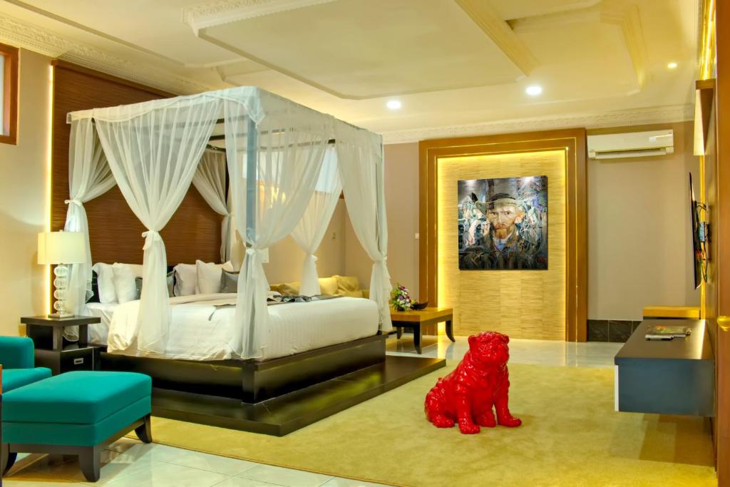 ein Schlafzimmer mit einem weißen Bett mit Baldachin in der Unterkunft Raintree Boutique Villa & Gallery in Yogyakarta