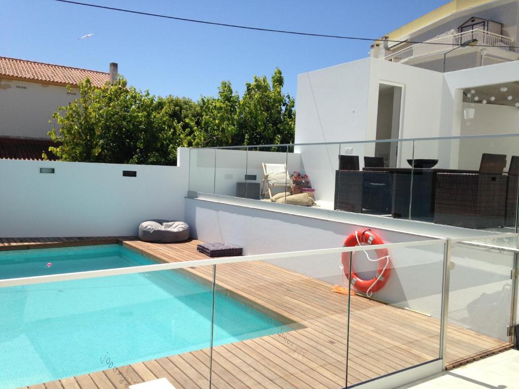 a balcony with a swimming pool and a house at Casa do Joaquim da Praia in Nazaré