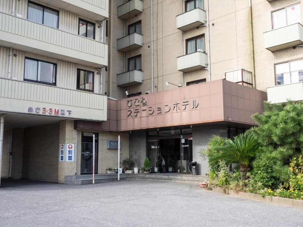 Hikone Station Hotel في هيكونا: مبنى امامه موقف سيارات